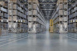 Huge distribution warehouse with high shelves and loaders. Bottom view.